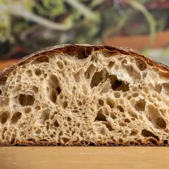 Schnitt eines rustikalen Brotes mit großer Porung, perfekt für ein Sylter Brot Rezept.