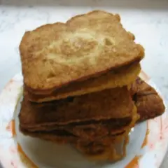 Ein Stapel goldbraunes Brot mit Ei, auf einem Teller angerichtet. Perfekt für ein herzhaftes Frühstück.