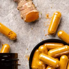 Curcuma-Kapseln und frische Wurzeln. Entdecke, was bewirkt Curcuma für dein Wohlbefinden.