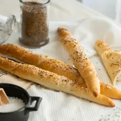 Goldbraune Salzstangen mit Kümmel und grobem Salz, bereit zum Genießen. So einfach kannst du Salzstangen selber machen!