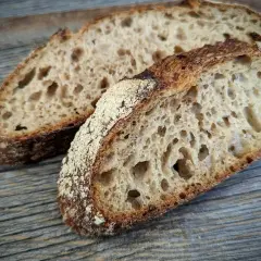 Zwei Scheiben rustikales Landbrot mit knuspriger Kruste und luftiger Krume, perfekt für ein einfaches Landbrot Rezept.