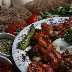 Würziges Gericht mit Hackfleisch, Tomaten und Paprika. Sumach-Verwendung zeigt sich in der rubinroten Gewürzmischung, die für Farbe und Aroma sorgt.
