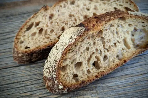 Zwei Scheiben rustikales Landbrot mit knuspriger Kruste und luftiger Krume, perfekt für ein einfaches Landbrot Rezept.