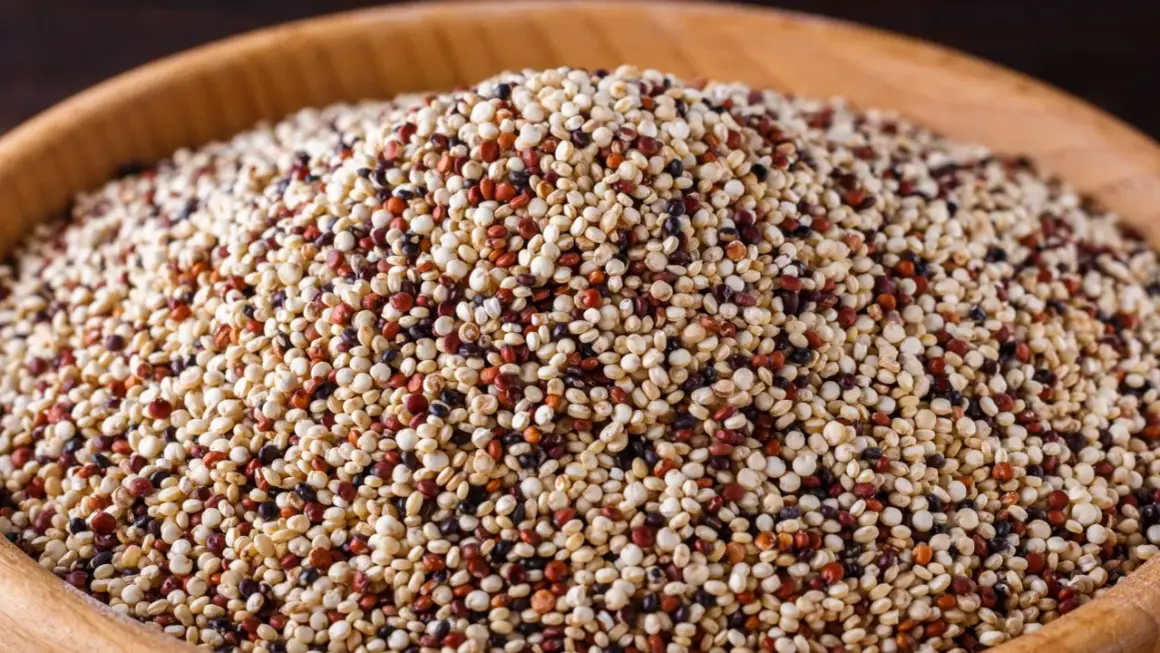 Ein Haufen bunter Quinoa, ein nährstoffreiches Pseudo-Getreide, in einer Holzschale.