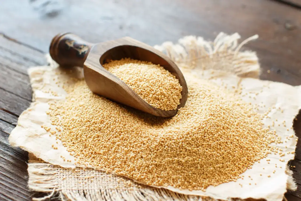 Holzschaufel mit Amaranth, einem n&auml;hrstoffreichen Pseudo-Getreide, auf rustikalem Leinen und Holz.