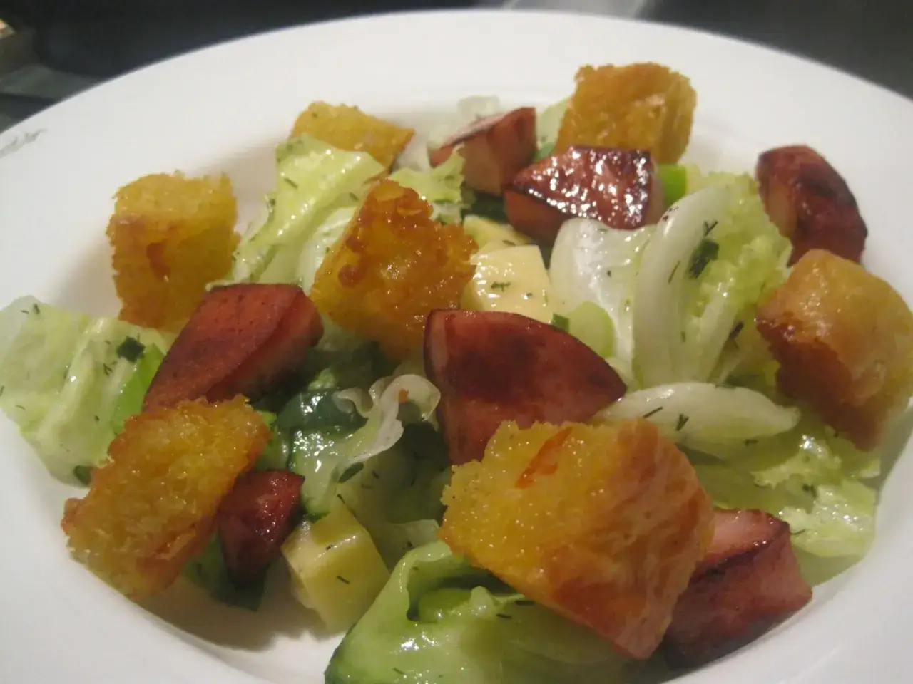 Herzhafter Brotsalat mit Roggenbrot-Croutons, Wurst und knackigem Salat.