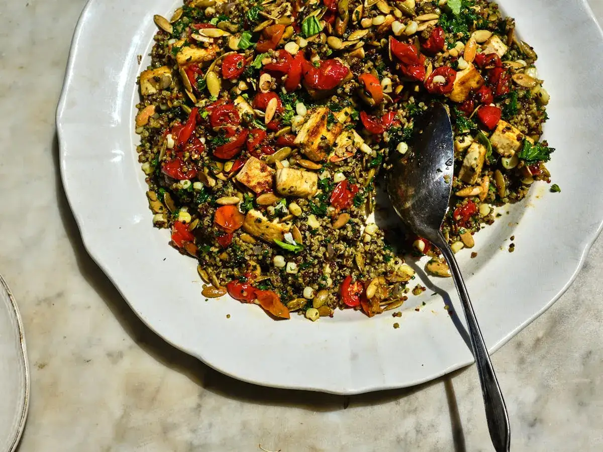 Bunter Quinoa-Salat mit geröstetem Halloumi, Kirschtomaten und Kürbiskernen. Trotz des leicht bitteren Quinoa ist er ein Genuss.
