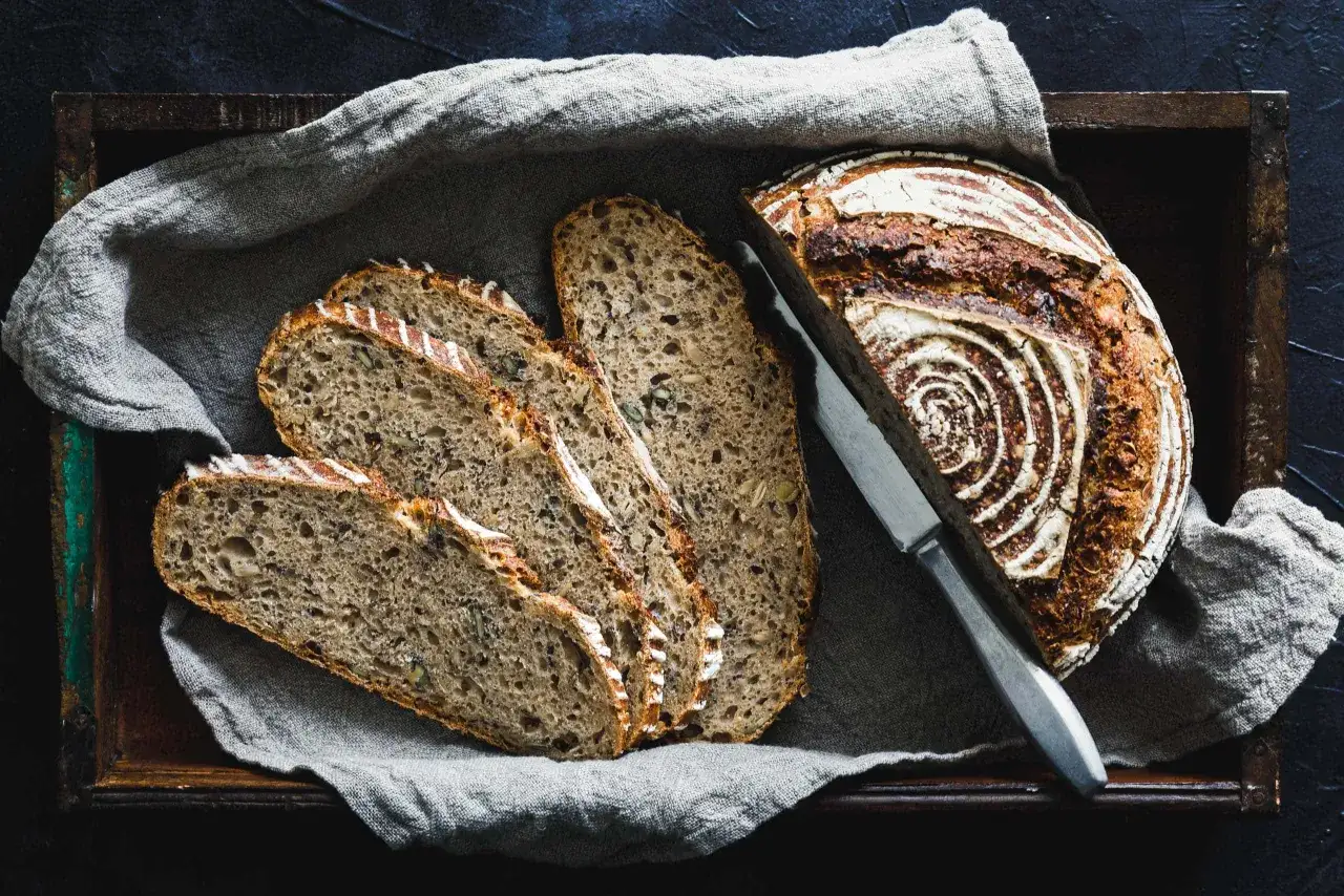 Rustikales Vollkornbrot mit Kernen, eine köstliche parboiled weizen alternative, liegt angeschnitten in einer Holzkiste.