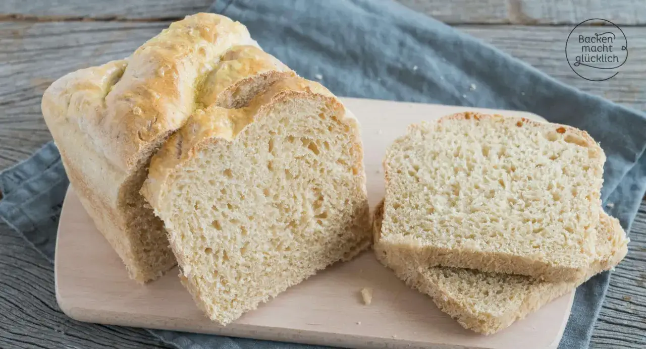 Frisch gebackenes Brot aus Hefe Teig, auf einem Holzbrett angeschnitten.