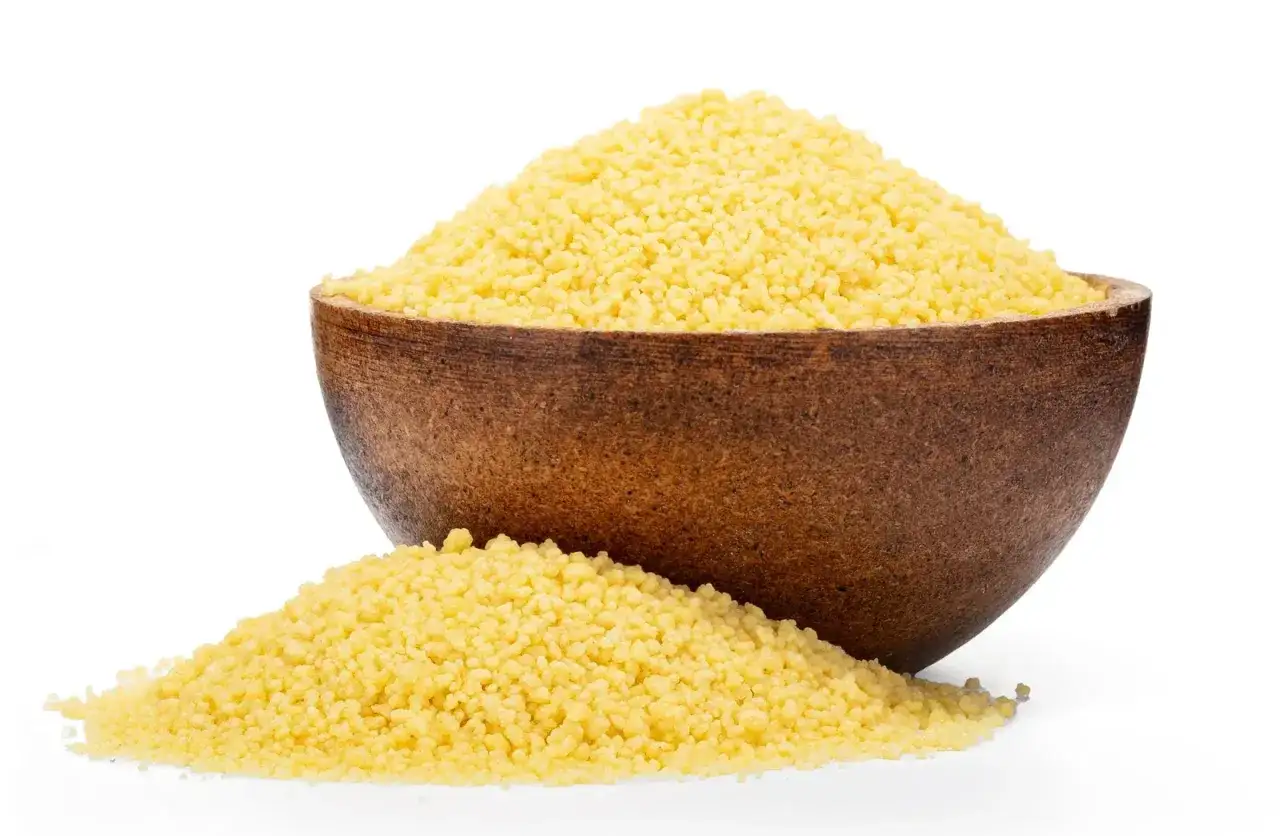 Eine Holzschale gef&uuml;llt mit hellem Couscous, daneben ein kleiner Haufen. Ideal f&uuml;r alle, die wissen wollen, ob hartweizen glutenfrei ist.